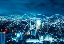 NextNav Inc. To Promote Open Source 5G and 6G Networks Night cityscape at blue hour with glowing network lines/arcs across the skyline, symbolizing global connectivity and communications.