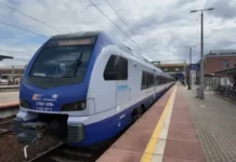 Rail Connectivity Takes to the Tracks with a Live LEO Trial Modern blue-and-white passenger train at a platform, ready for boarding, with bikes and station buildings in the background.