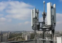 Kyivstar Network Migration Expands 4G Capacity in Ukraine Cellular antenna mast on a rooftop with cables, overlooking a city skyline under a blue sky.