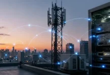 SK Telecom Proposes RCS Standard for AI Agent Transaction Approvals Rooftop telecom tower beside a server rack, with glowing blue network lines linking nodes over a city skyline at sunset.
