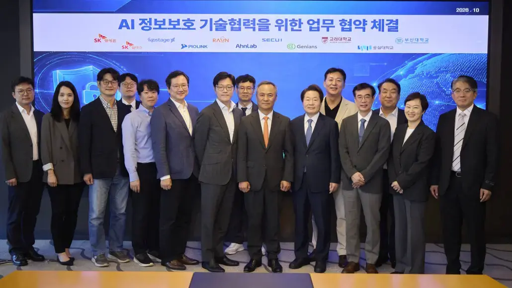 Group of professionals posing for a ceremony photo in front of a banner that reads 'AI 정보보호 기술협력을 위한 업무 협약 체결'.